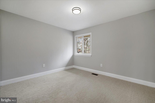 empty room with visible vents, carpet flooring, and baseboards