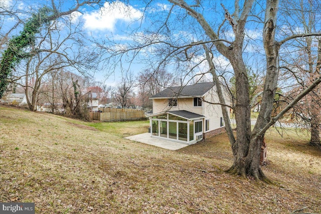 view of yard featuring fence and a sunroom