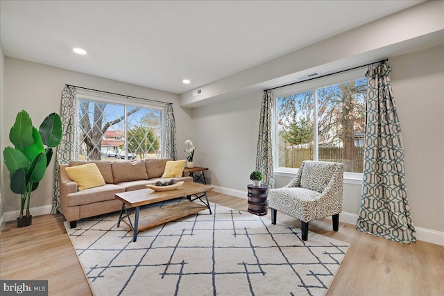 living area with recessed lighting, light wood-style flooring, and baseboards