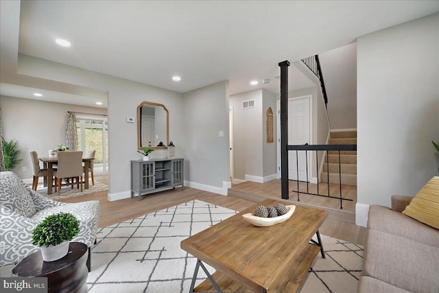 living area with stairs, recessed lighting, wood finished floors, and visible vents