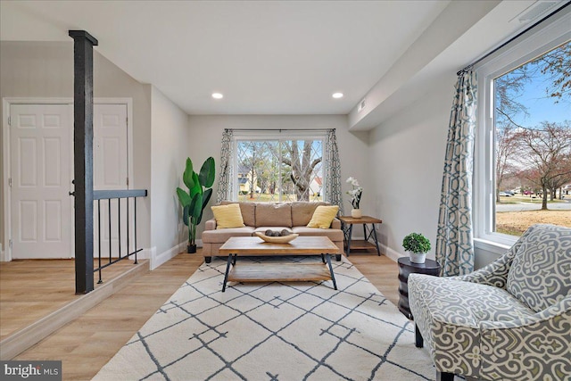 living area with recessed lighting, light wood-type flooring, and baseboards