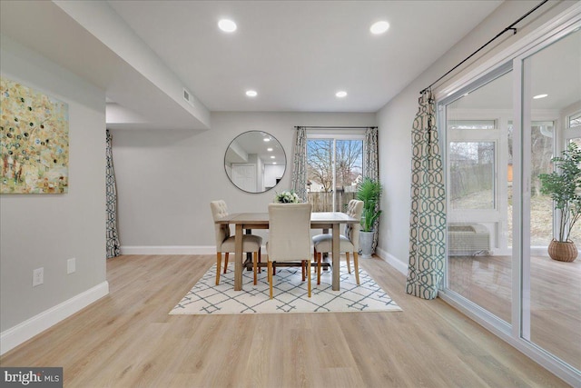 dining space featuring wood finished floors, visible vents, baseboards, a wall mounted AC, and recessed lighting