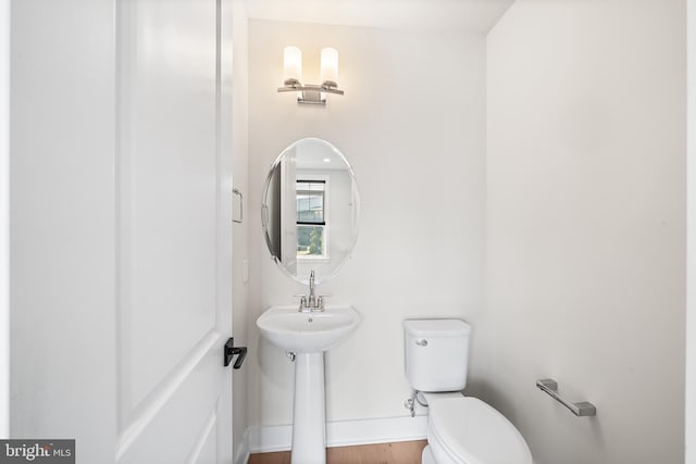 half bathroom with toilet and baseboards