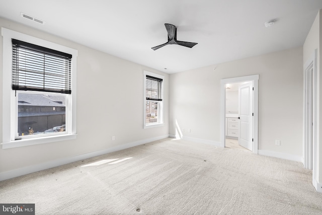 unfurnished bedroom with visible vents, ensuite bath, carpet, baseboards, and ceiling fan