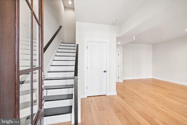 staircase with recessed lighting, baseboards, and wood finished floors