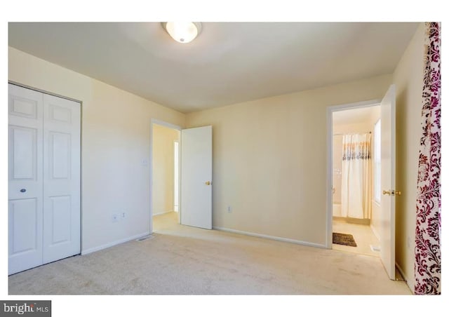 unfurnished bedroom with carpet, a closet, and baseboards