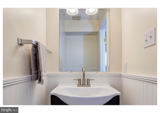 bathroom featuring vanity, visible vents, and wainscoting