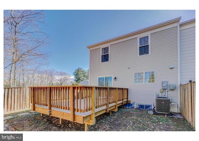 rear view of property with central air condition unit, fence, and a wooden deck