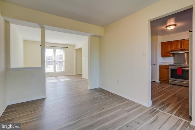 spare room with wood finished floors and baseboards