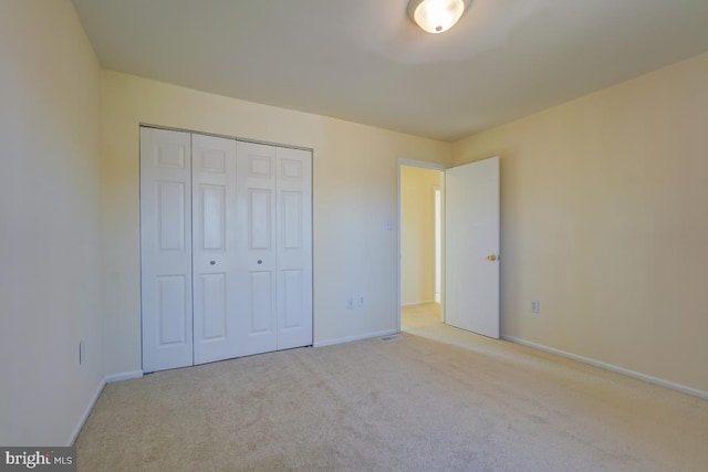 unfurnished bedroom featuring a closet, baseboards, and carpet