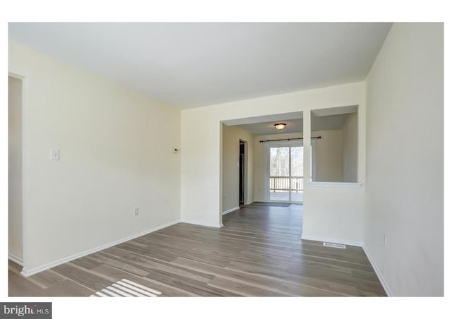 unfurnished room with wood finished floors and baseboards