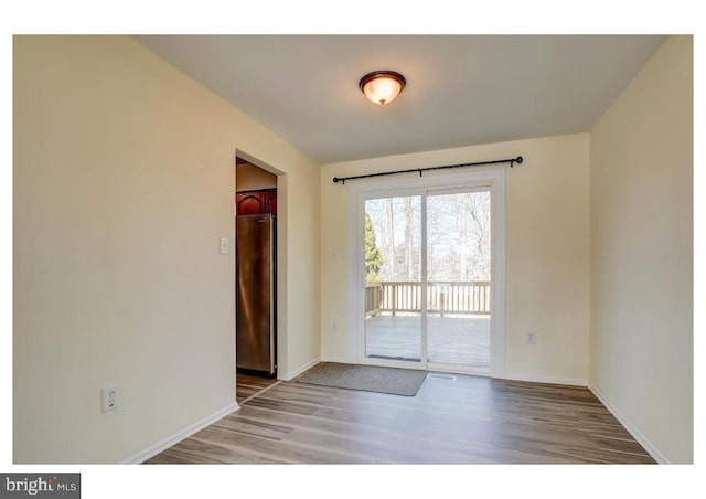 empty room featuring baseboards and wood finished floors