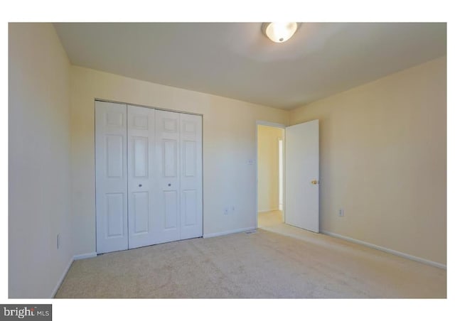 unfurnished bedroom featuring baseboards, a closet, and carpet floors