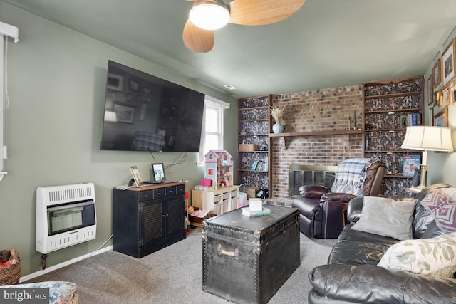 living room featuring heating unit, ceiling fan, a brick fireplace, and carpet