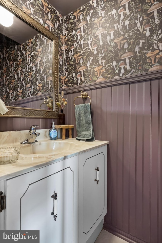 bathroom with a wainscoted wall, vanity, and wallpapered walls