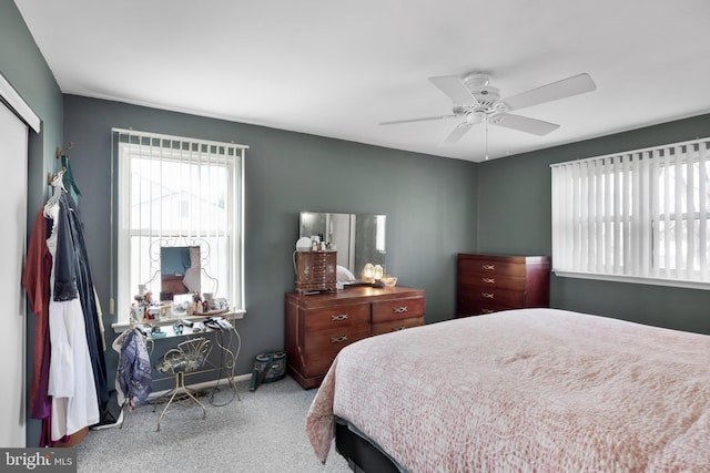 carpeted bedroom featuring a closet, baseboards, and a ceiling fan