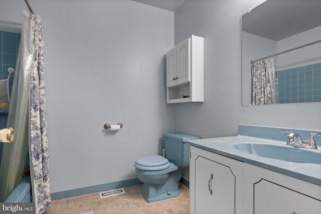 bathroom with visible vents, toilet, curtained shower, baseboards, and vanity