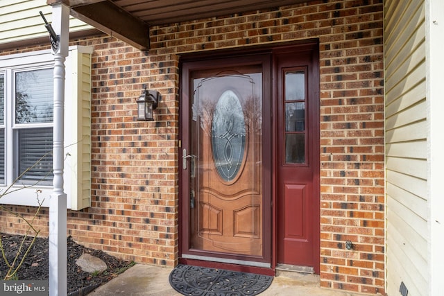 view of exterior entry with brick siding