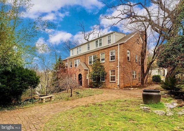 colonial house featuring brick siding