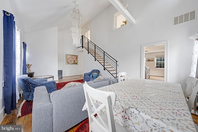 interior space featuring visible vents, stairway, a high ceiling, and wood finished floors