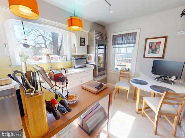 kitchen featuring light countertops, high quality fridge, and a wealth of natural light