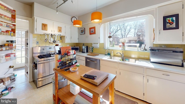 kitchen with a sink, backsplash, appliances with stainless steel finishes, and light countertops