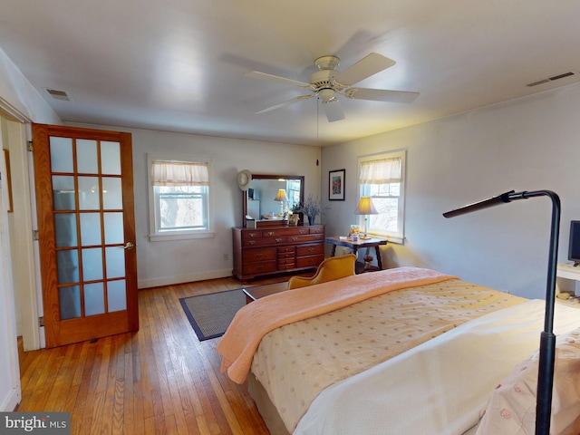 bedroom with visible vents, multiple windows, and wood-type flooring