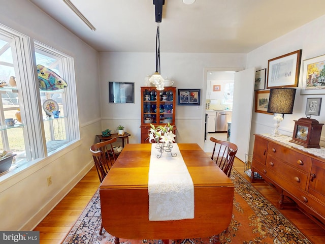 dining area with light wood-type flooring and baseboards