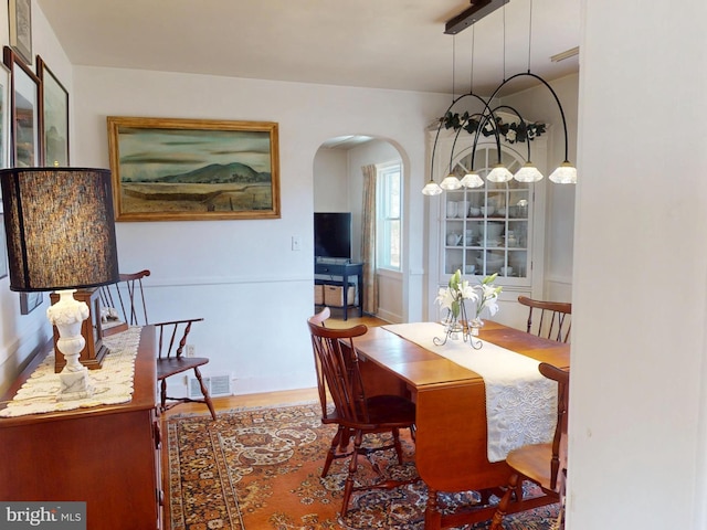 dining space with visible vents and arched walkways