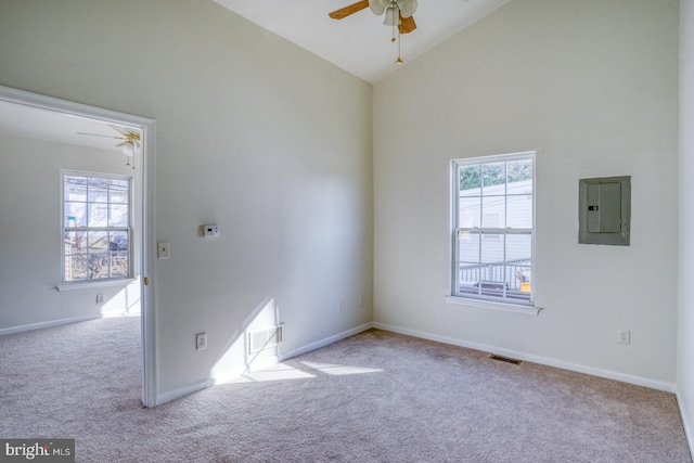 unfurnished room with electric panel, visible vents, carpet flooring, and a wealth of natural light