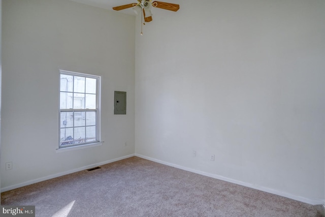 spare room with a ceiling fan, baseboards, visible vents, electric panel, and carpet flooring