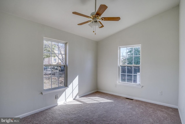 carpeted spare room featuring visible vents, baseboards, ceiling fan, and vaulted ceiling