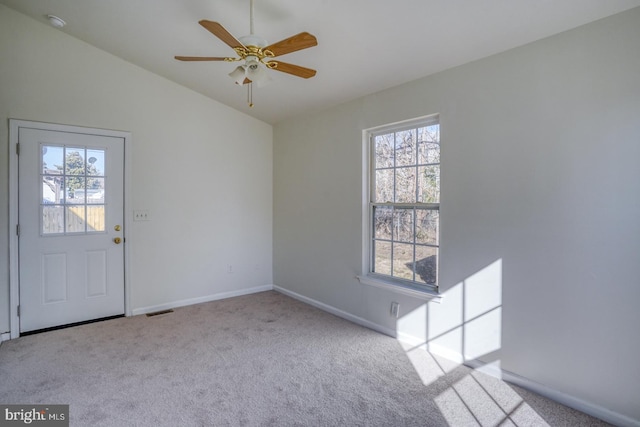 spare room with visible vents, lofted ceiling, carpet, and baseboards