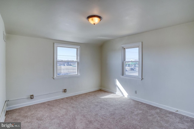 empty room featuring plenty of natural light, baseboards, and carpet floors