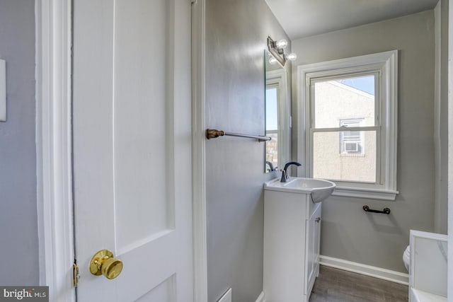 bathroom featuring vanity, toilet, wood finished floors, and baseboards