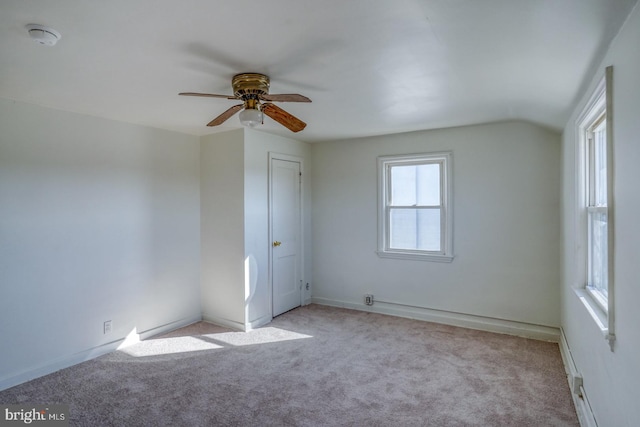 spare room with vaulted ceiling, a ceiling fan, and carpet floors