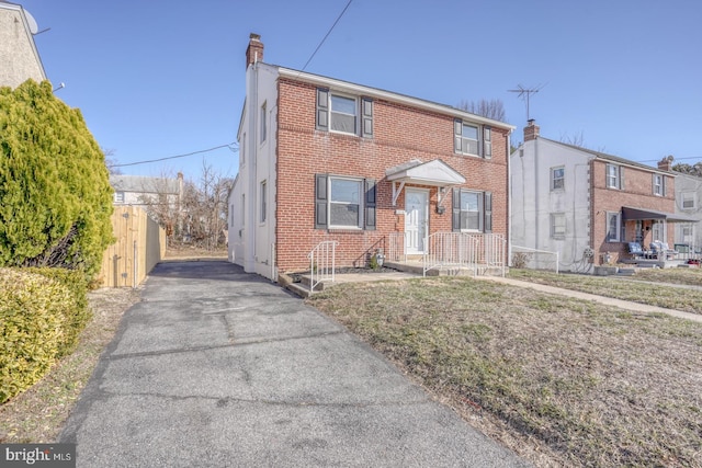 view of front of property featuring brick siding and a chimney