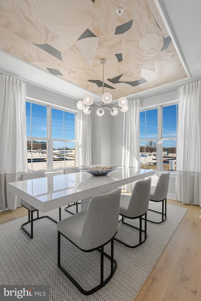 dining room featuring a notable chandelier, wood finished floors, and crown molding