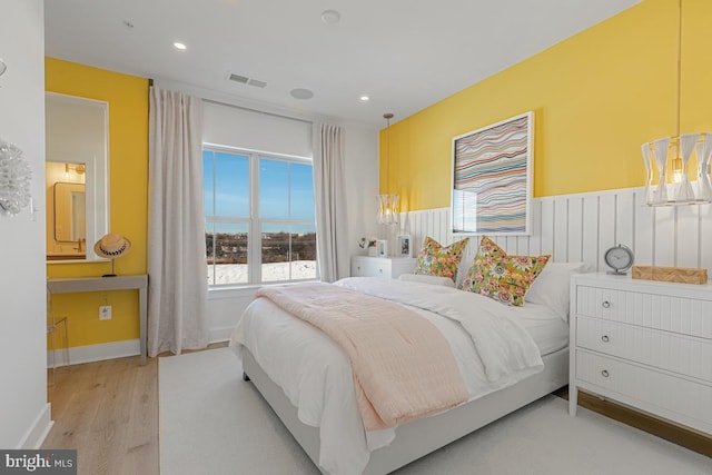 bedroom featuring recessed lighting, wood finished floors, visible vents, and wainscoting