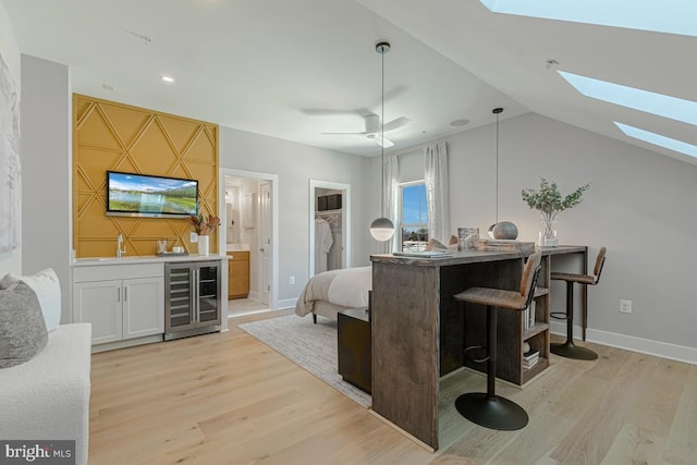 bar with lofted ceiling, light wood-style flooring, wine cooler, wet bar, and baseboards