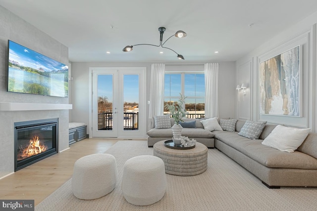 living area with a fireplace, recessed lighting, and light wood-style floors