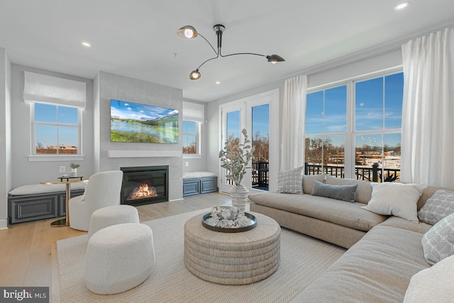 living area featuring recessed lighting, a large fireplace, and wood finished floors