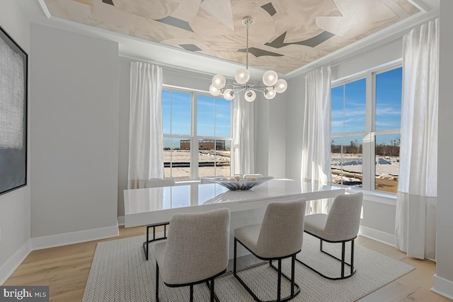 dining space featuring a notable chandelier, light wood-style flooring, plenty of natural light, and baseboards