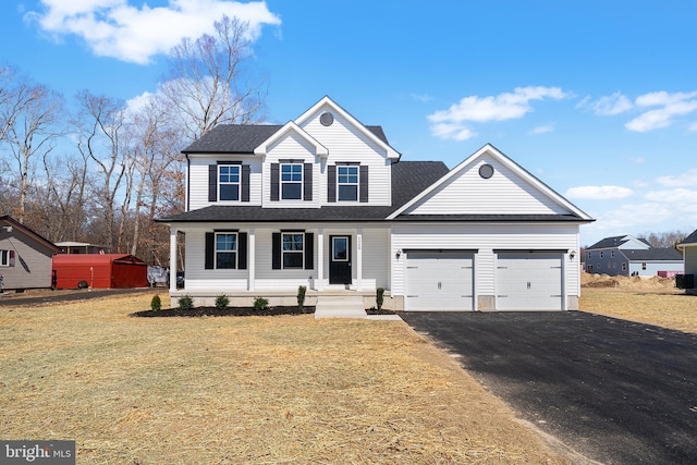 traditional-style house featuring aphalt driveway, a garage, a front yard, and a shingled roof