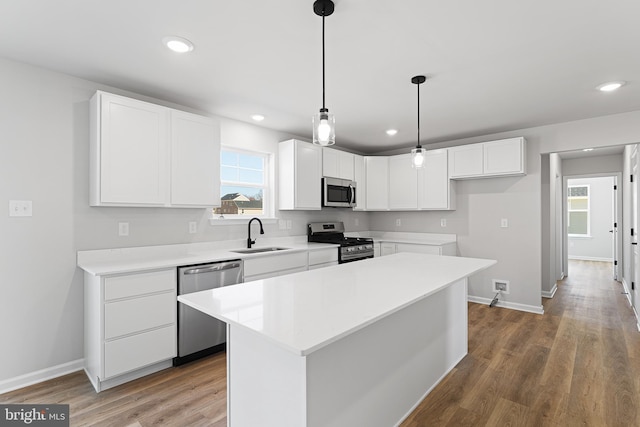 kitchen featuring a sink, light wood-style flooring, white cabinetry, and stainless steel appliances