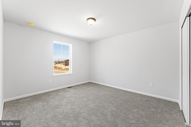 unfurnished room with baseboards and carpet floors