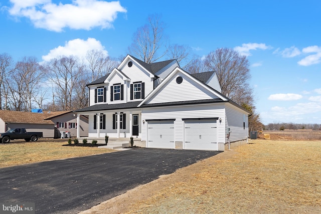 traditional-style home with a garage, a front lawn, driveway, and a shingled roof