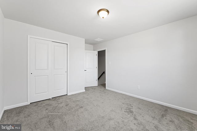 unfurnished bedroom featuring a closet, baseboards, and carpet floors