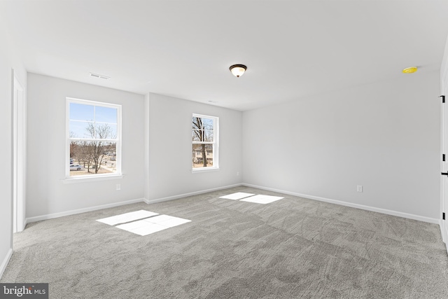 empty room featuring visible vents, baseboards, and carpet floors