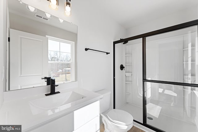 full bathroom featuring visible vents, toilet, a stall shower, and vanity